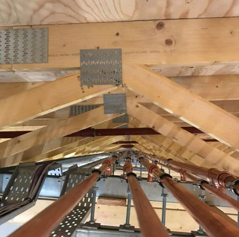 Pipework running under roof trusses